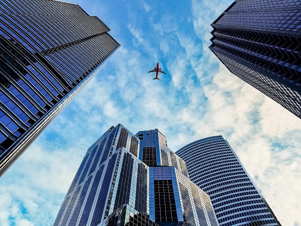 An aircraft above tall city buildings 